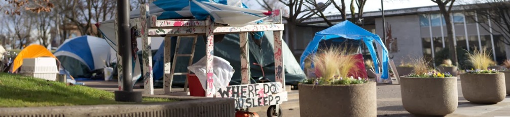 Homelessness is a hot political issue in Eugene. Here, members of a makeshift community occupy the plaza in front of city hall, Eugene City Center. A display in front of the camp asks passersby a poignant question - where do you sleep?